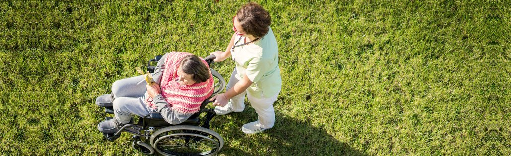 caregiver and senior woman strolling